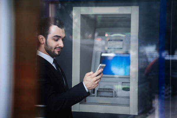 Picture of a man by an ATM.