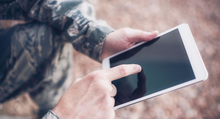 Picute of a soldier using a tablet.
