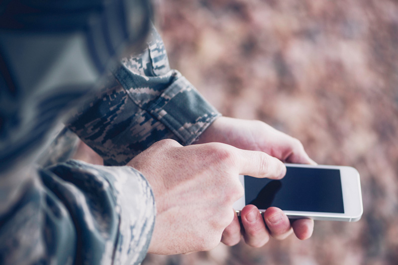 Zdjęcie żołnierza korzystającego z telefonu.