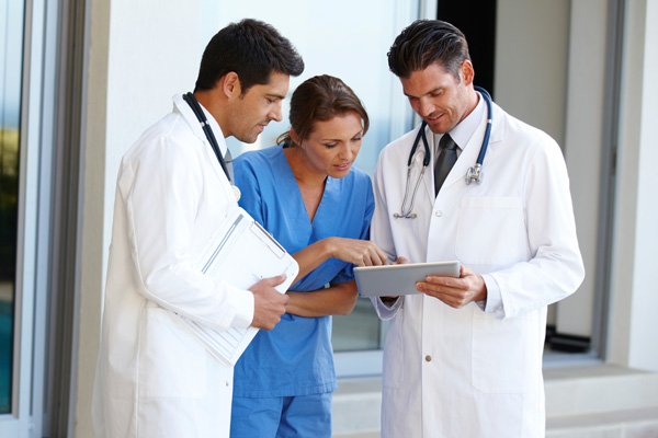Zdjęcie lekarzy korzystających z tabletu.